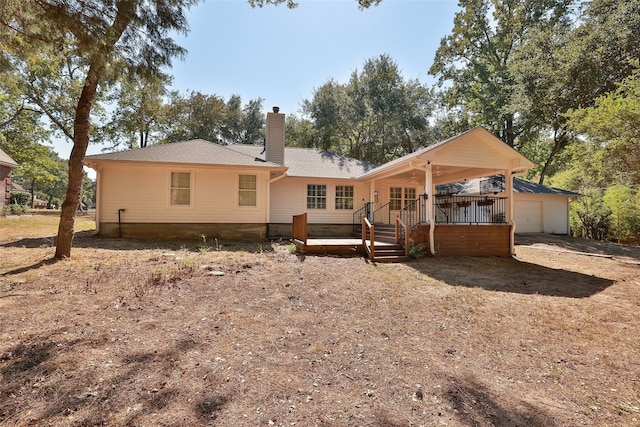 back of property with a porch, an outdoor structure, and a garage