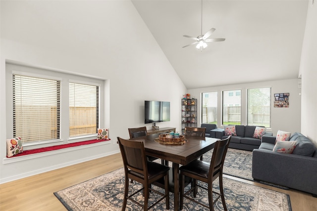 dining area with high vaulted ceiling, hardwood / wood-style flooring, and ceiling fan