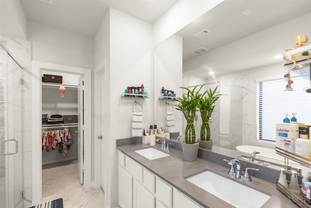 bathroom featuring vanity and independent shower and bath