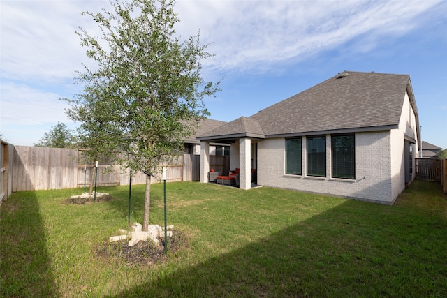 rear view of property with a yard