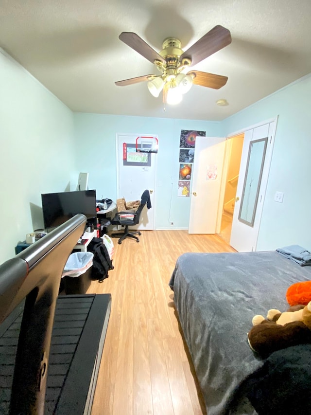 bedroom with hardwood / wood-style floors, ceiling fan, and a closet