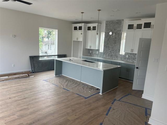 kitchen featuring white cabinets, dark hardwood / wood-style flooring, a center island, and decorative light fixtures