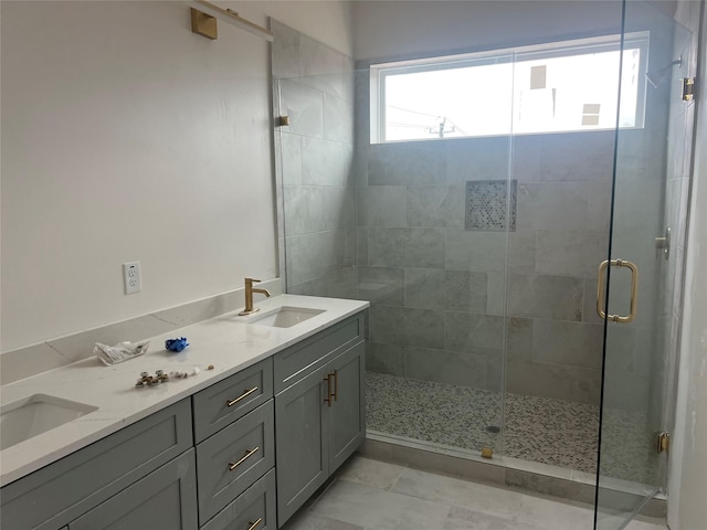 bathroom with a shower with door, vanity, and tile patterned flooring