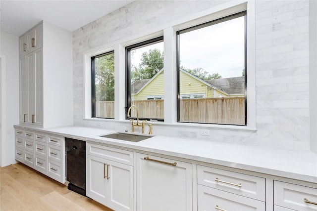 kitchen with sink, light wood-type flooring, and white cabinetry