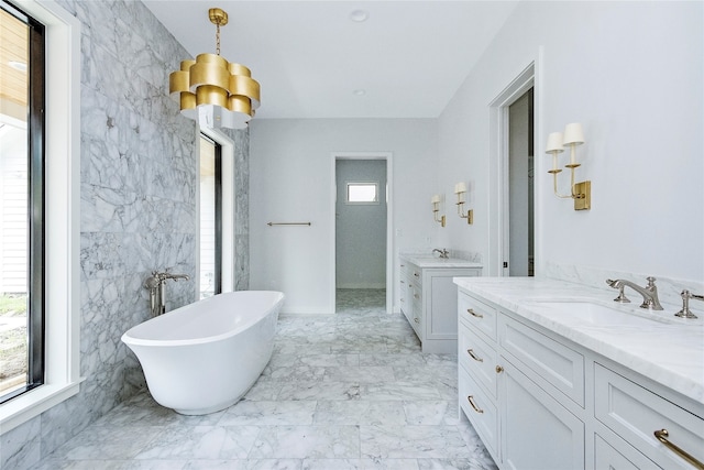 bathroom featuring vanity, a bathtub, tile walls, and a wealth of natural light