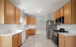 kitchen with stainless steel appliances, tasteful backsplash, and light tile patterned flooring