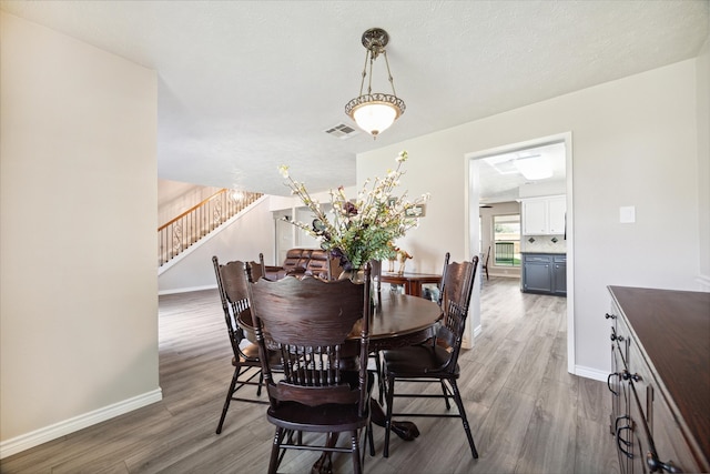 dining space featuring hardwood / wood-style floors and a textured ceiling