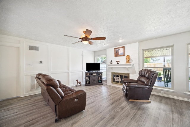 living room featuring hardwood / wood-style floors, a textured ceiling, and ceiling fan