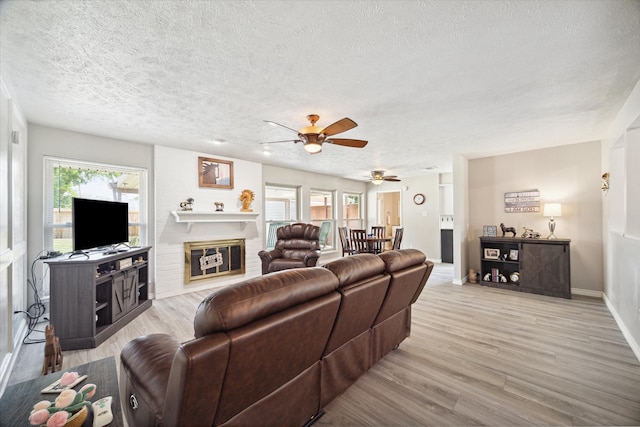 living room with wood-type flooring, a textured ceiling, and ceiling fan