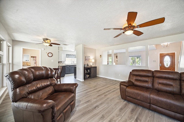 living room featuring ceiling fan, wood-type flooring, and a textured ceiling