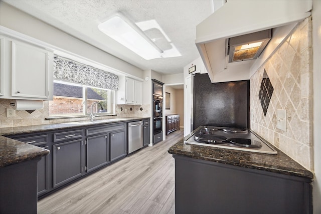 kitchen featuring white cabinetry, dishwasher, white cooktop, and light hardwood / wood-style floors