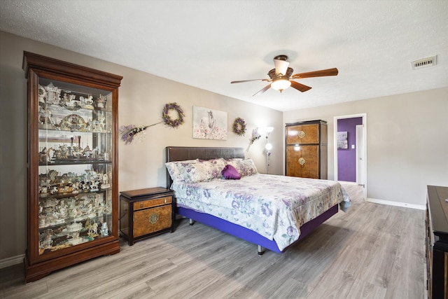 bedroom with wood-type flooring, a textured ceiling, and ceiling fan