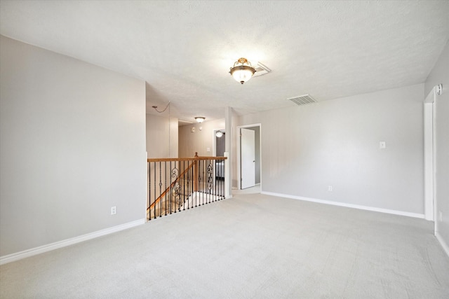 empty room featuring carpet flooring and a textured ceiling