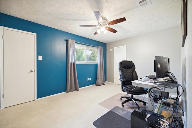 home office featuring a textured ceiling, ceiling fan, and light carpet