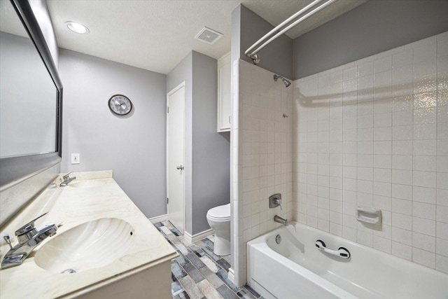 full bathroom with hardwood / wood-style floors, tiled shower / bath combo, toilet, and vanity