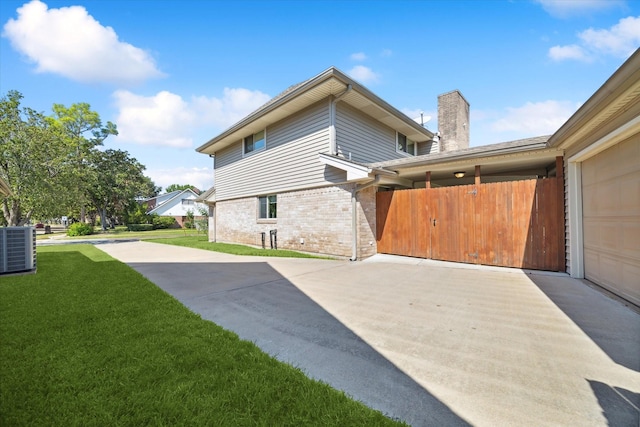 view of home's exterior with a lawn and central AC