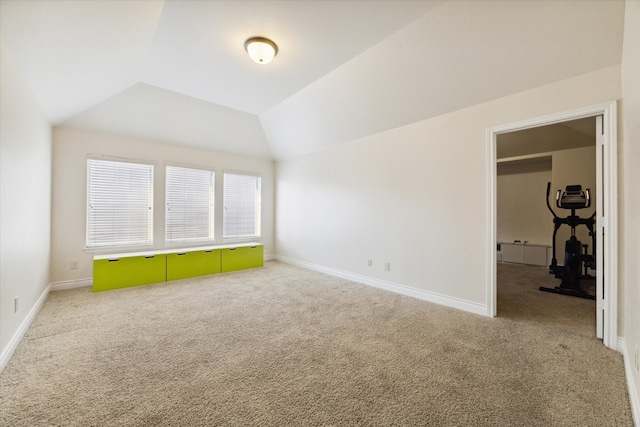 empty room featuring vaulted ceiling and carpet flooring