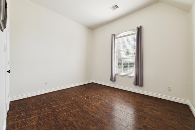 empty room featuring lofted ceiling and dark hardwood / wood-style flooring