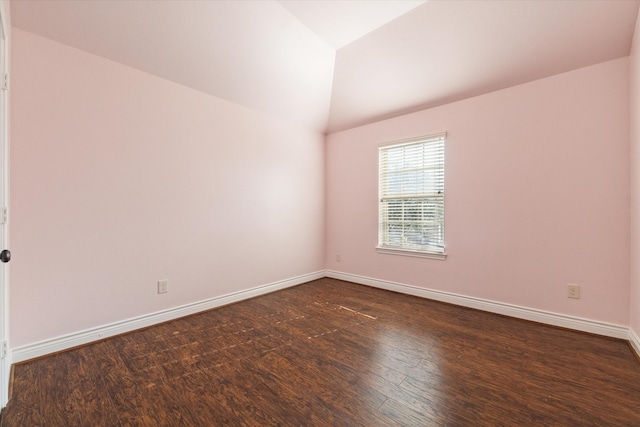 empty room featuring vaulted ceiling and dark hardwood / wood-style floors