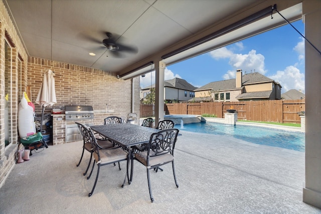 view of patio with area for grilling, ceiling fan, a fenced in pool, and an outdoor kitchen