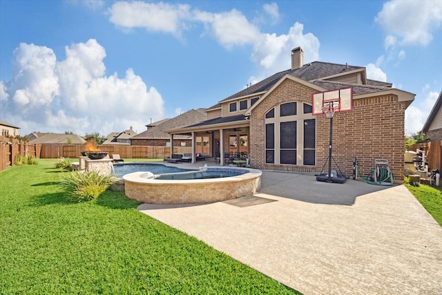 back of property featuring a yard, a patio area, and a pool with hot tub