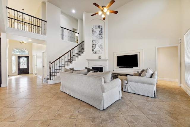 living room featuring ceiling fan, a towering ceiling, and light tile patterned floors