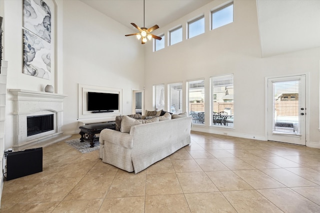 living room featuring a towering ceiling, light tile patterned flooring, and ceiling fan