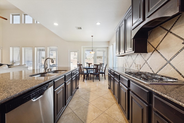 kitchen featuring a healthy amount of sunlight, stainless steel appliances, sink, and dark stone countertops