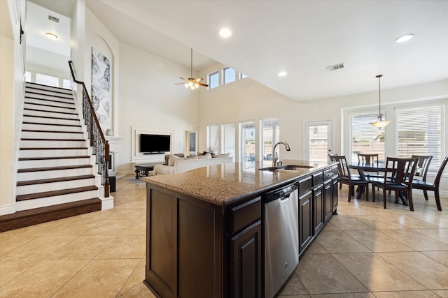 kitchen with sink, dishwasher, ceiling fan, decorative light fixtures, and a kitchen island with sink