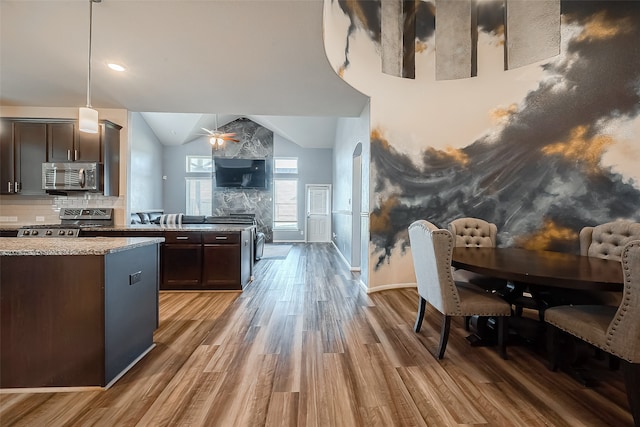 kitchen with ceiling fan, dark brown cabinetry, decorative light fixtures, stainless steel appliances, and hardwood / wood-style flooring