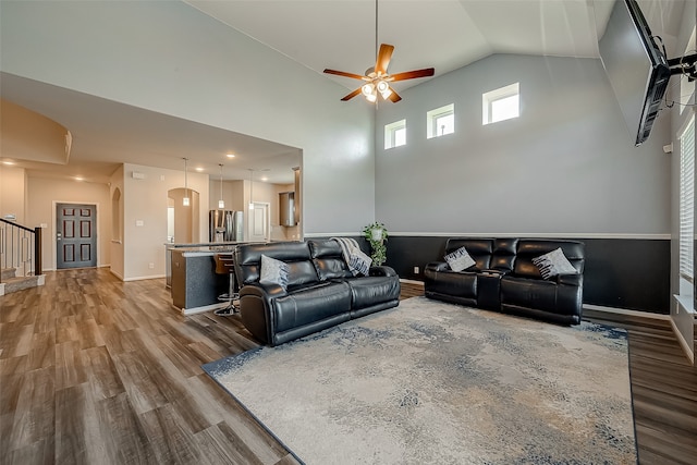 living room with wood-type flooring, high vaulted ceiling, and ceiling fan