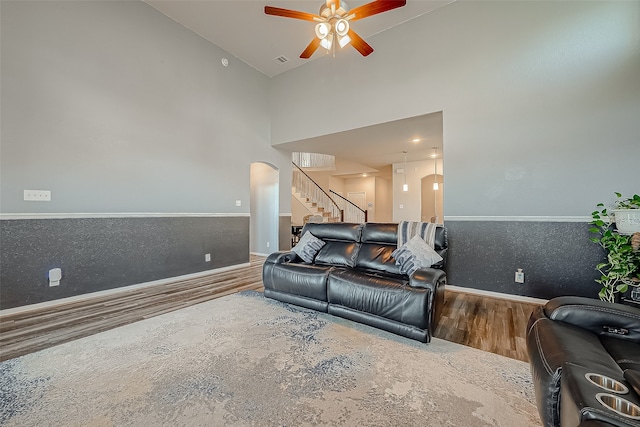 living room with high vaulted ceiling, ceiling fan, and wood-type flooring