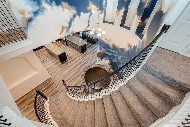 staircase featuring an inviting chandelier and hardwood / wood-style floors