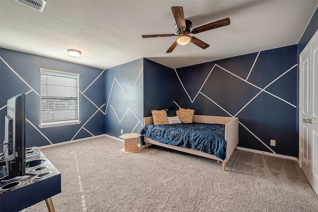 bedroom with ceiling fan, a textured ceiling, and carpet flooring