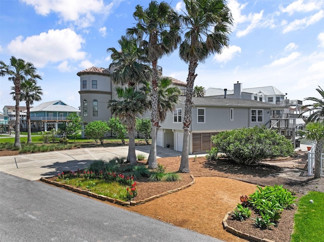 1239 Oahu Dr, Tiki Island, TX 77554 - view of front of property with an attached garage, concrete driveway, and stucco siding
