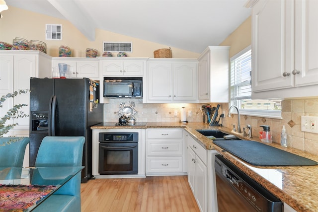 1239 Oahu Dr, Tiki Island, TX 77554 - kitchen featuring black appliances, a sink, white cabinets, light wood-type flooring, and backsplash