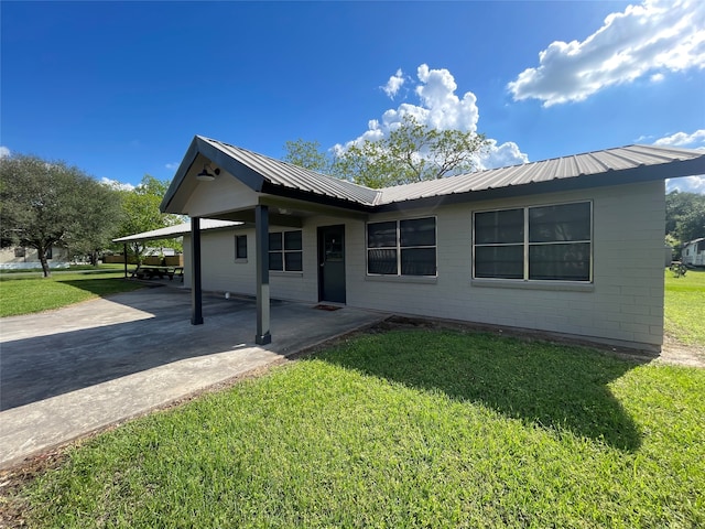 back of house featuring a carport and a lawn