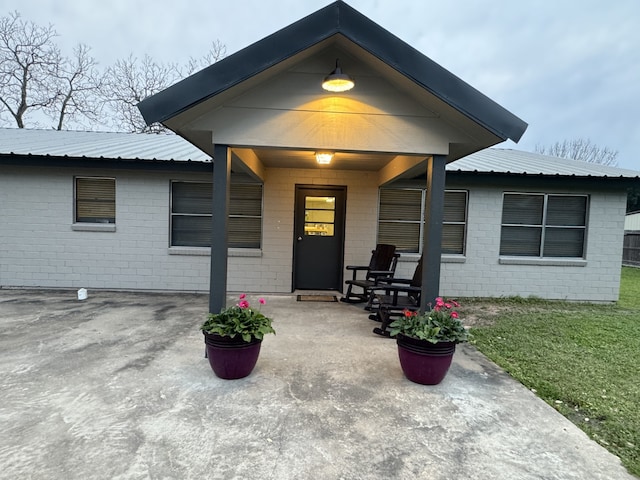 view of exterior entry featuring a lawn