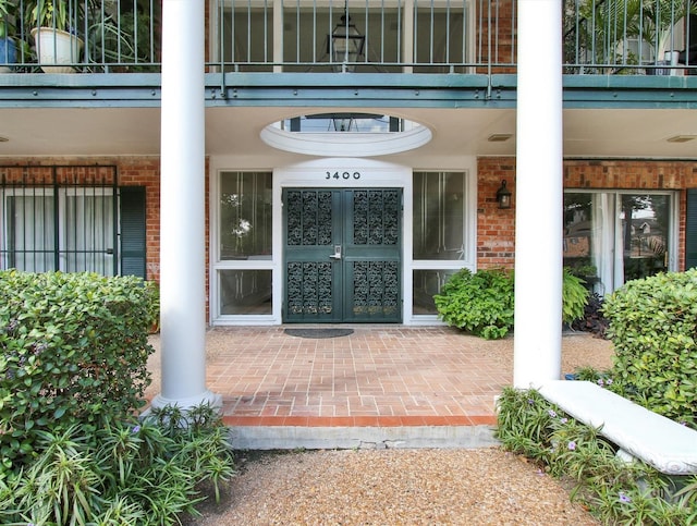 view of exterior entry with french doors and a balcony