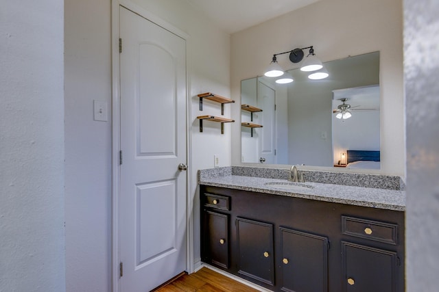 bathroom featuring ceiling fan, hardwood / wood-style floors, and vanity