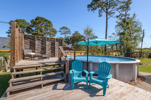 wooden terrace featuring a fenced in pool