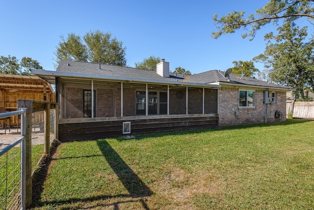 back of house with a yard and a sunroom