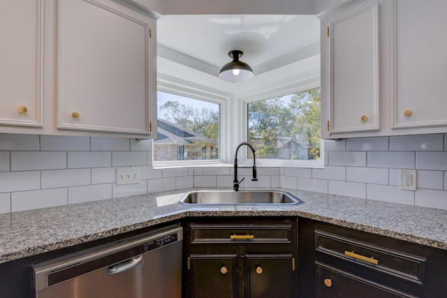 kitchen featuring backsplash, dishwasher, white cabinetry, and sink