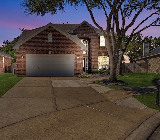 view of front of property with a yard and central AC unit