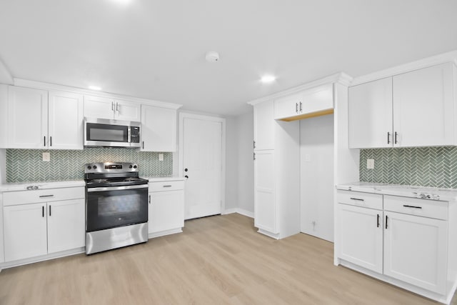 kitchen featuring white cabinets, light hardwood / wood-style floors, and appliances with stainless steel finishes