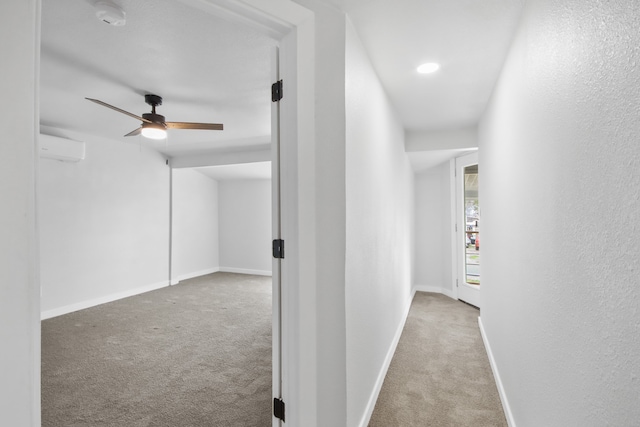 hallway with light carpet and a wall mounted AC