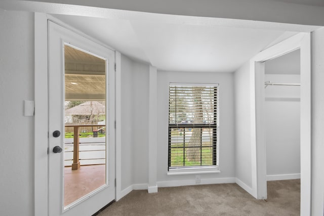 doorway featuring a healthy amount of sunlight and light carpet