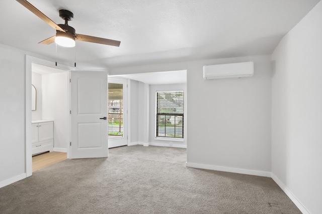 carpeted empty room featuring a wall unit AC and ceiling fan