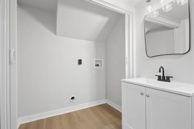 clothes washing area featuring hookup for an electric dryer, washer hookup, light wood-type flooring, and sink