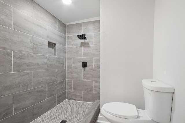 bathroom with tiled shower and toilet